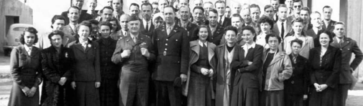 black and white photo of dozens of people standing on stairs looking at the camera